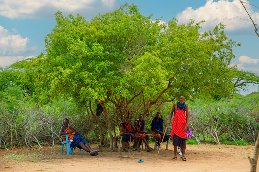 Kenya Africa ,16 oktober 2019. men from the African tribe Masai in national dress in full growth against the backdrop of their traditional village