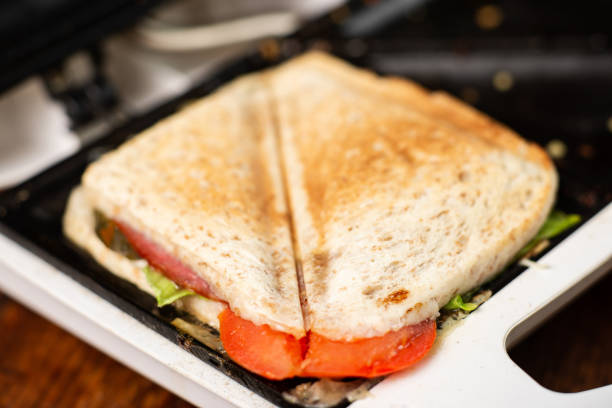istock Grilled sandwich with herbs and tomato cooked in a sandwich maker close-up. 1473978498