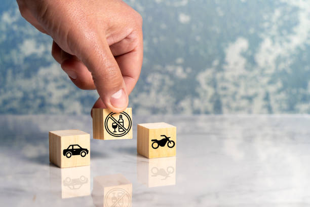 Person conceptualizes with wooden cubes the prohibition of drinking alcoholic beverages while driving a motor vehicle stock photo