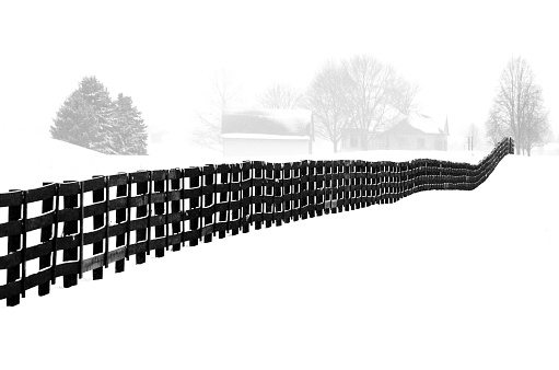 Black fence in Winter snow rural scenic landscape.