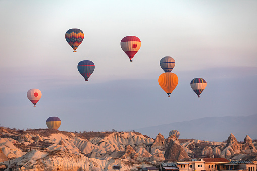 Hot air balloons flying over mountains in Cappadocia