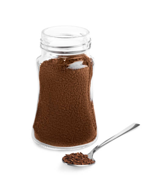 istock Spoon and glass jar with instant coffee on white background 1473989419