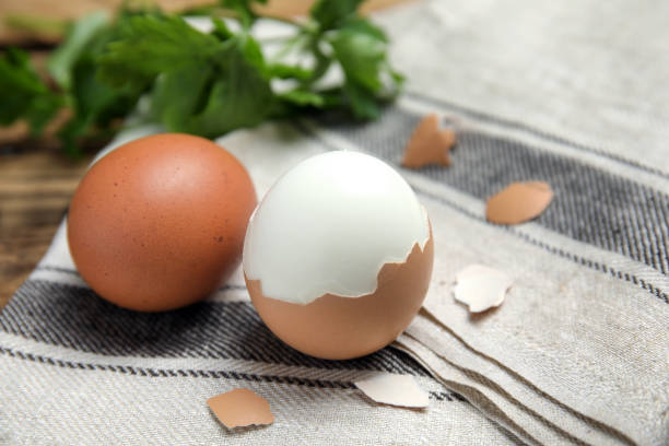 istock Boiled eggs and pieces of shell on kitchen towel, closeup 1473990015