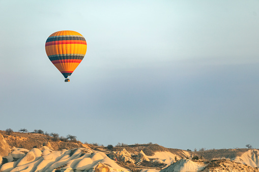 Rocamadour, France - 24th September 2023: A hot air balloon appears to pass dangerously close to a cliff edge and spectators during the Montgolfiades de Rocamadour balloon festival in France