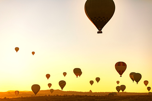 Hot air balloons flying at sunrise in Cappadocia