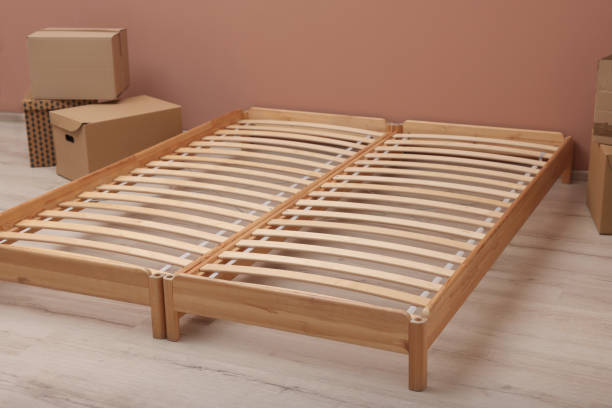 istock Wooden bed frame and cardboard boxes on floor in room 1473993063