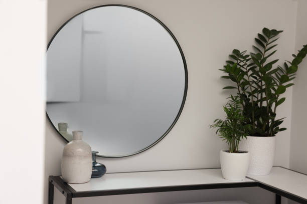 istock Stylish hallway interior with round mirror and beautiful green plants 1473993096