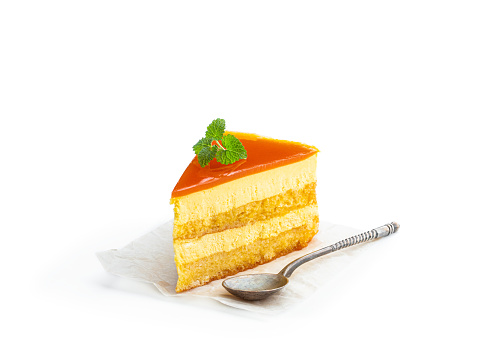 Slice  of layered mango cheesecake isolated on white