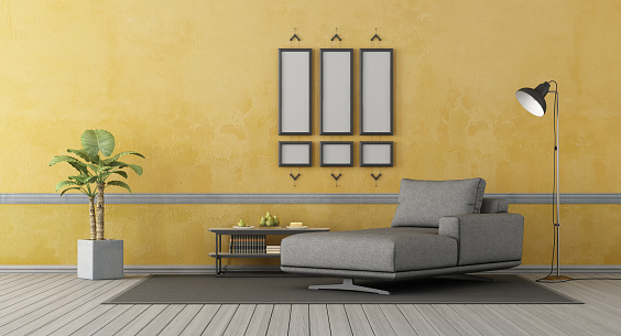 Gray chaise lounge om old yellow wall, empty picture frame and floor lamp - 3d rendering