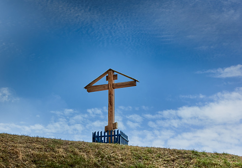 Large wooden cross in the glade on the top of the Somló Hill on a sunny day in springtime.