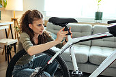 Young woman is repairing her bicycle seat