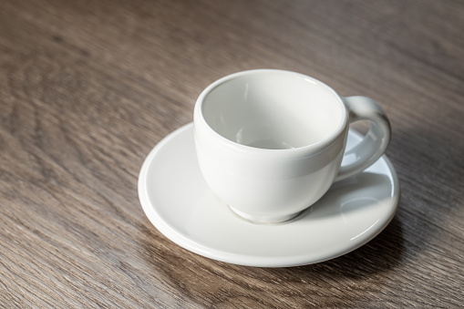 Empty white coffee cup on wooden background, close up