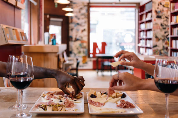 multiethnic hands picking up food from the dishes on table at the restaurant cafe - tapas aperitif time concept - coral break imagens e fotografias de stock