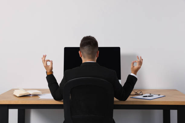 istock Businessman meditating at workplace, back view. Zen concept 1473998585