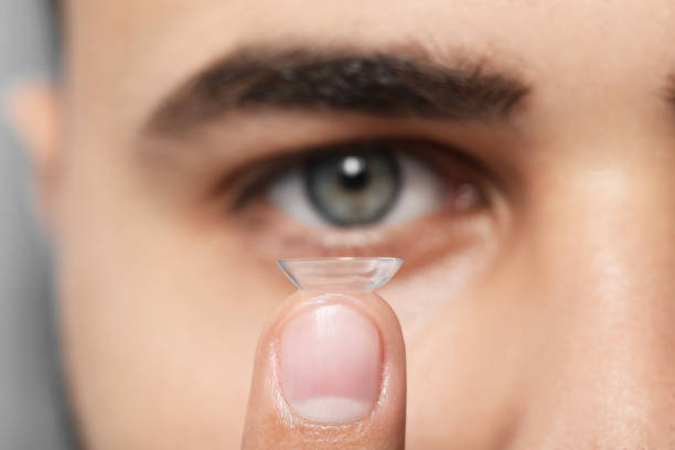 istock Young man with contact lens, focus on finger 1473998792