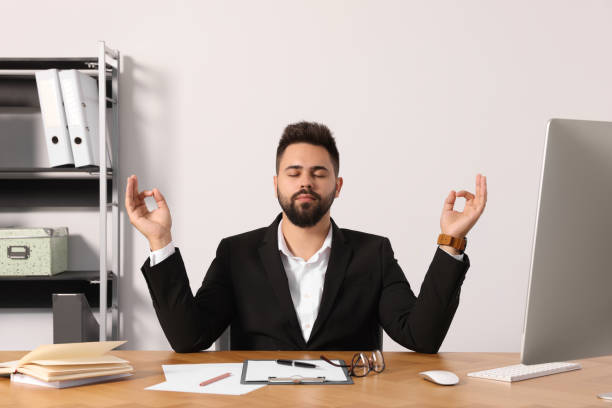 istock Young businessman meditating at workplace. Zen concept 1473999002