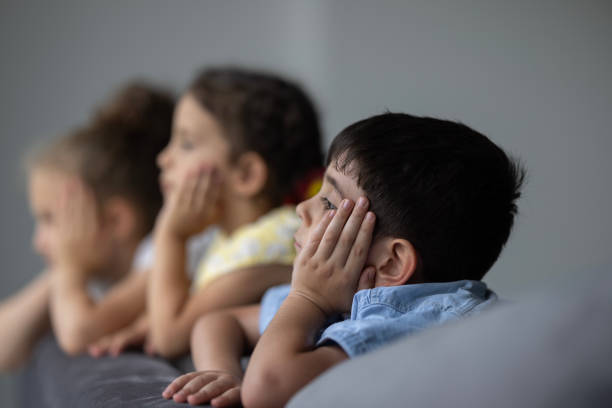 istock Little children watching the rain through the window 1474000146