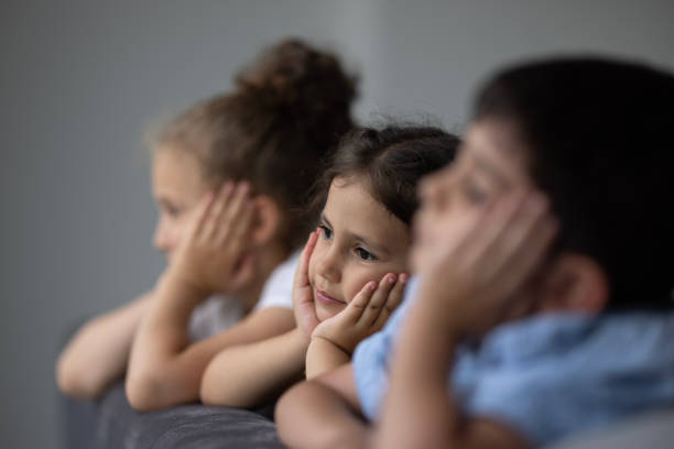 istock Little children watching the rain through the window 1474000242