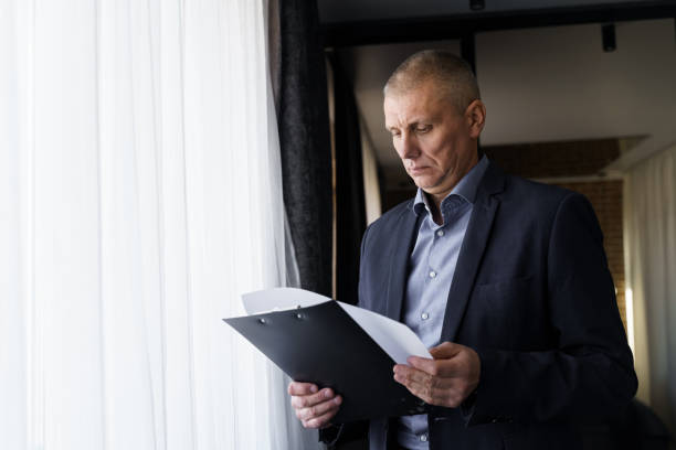 istock A businessman is worth a window in the office studies documents. 1474000270