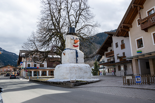 Wagrain, Austria - March 11, 2023: A huge snowman on the main square in a small mountain town.