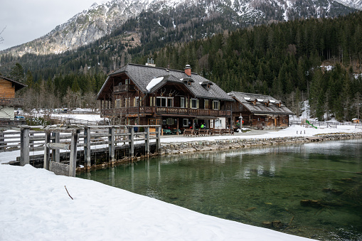 Jagersee, Austria - March 11, 2023: Old wooden building of excursion restaurant on the shore of Jagersee lake in winter in Austria.