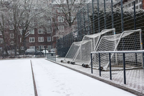 Football field and goal nets covered in  white snow during winter