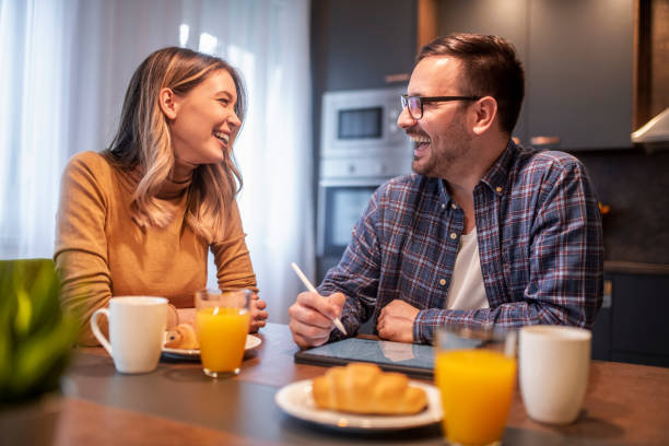 Couple using digital tablet and having breakfast stock photo
