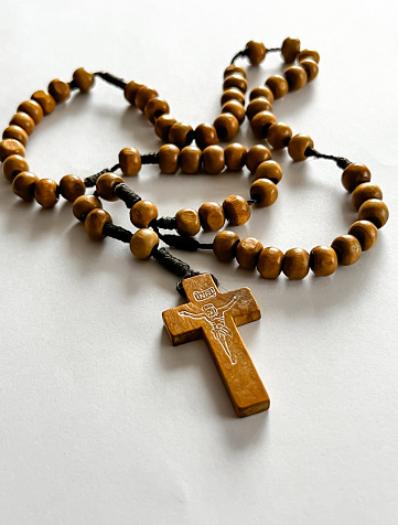 wooden rosary lying on a white sheet of paper