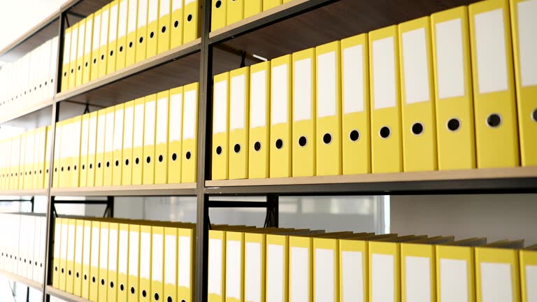 Identical yellow folders on shelf in archive