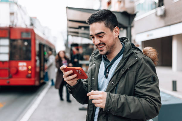 istock Man waiting for transportation and watching a video 1474015712
