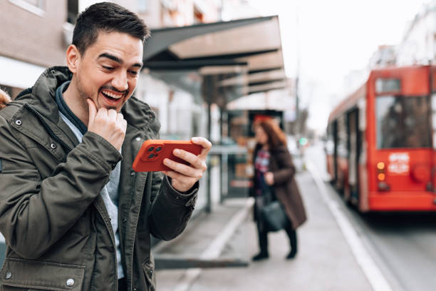 istock Man watching an interesting video, while at the bus station 1474015714