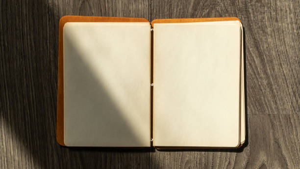 istock Notepad with blank pages on wooden table. High angle view of open notebook copy space for text. Taking notes concept. 1474016283