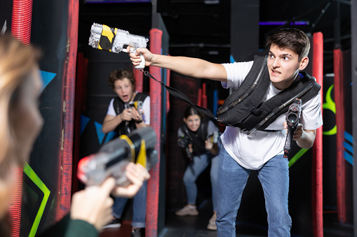 Young guy playing lasertag in arena
