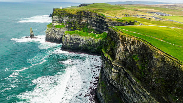 The Cliffs of Moher are sea cliffs located at the southwestern edge of the Burren region in County Clare, Ireland. The cliffs rank among the most visited tourist sites in Ireland, with around 1.5 million visits per year. vista aérea de los acantilados de moher, acantilado de moher irlanda, vista aérea de los acantilados de moher en la costa oeste de irlanda, irlanda acantilados piedra de roca, relax vista a la naturaleza, vista aérea a la naturaleza vista al mar, irland