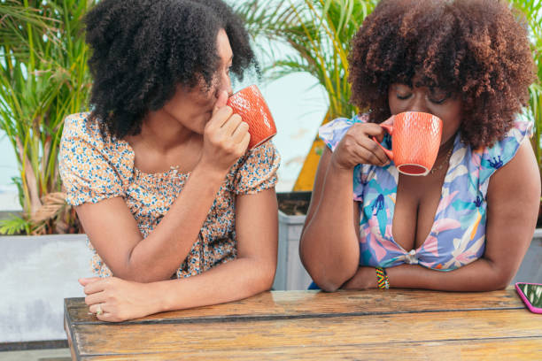 istock Two attractive women drinking coffee in the park 1474022864