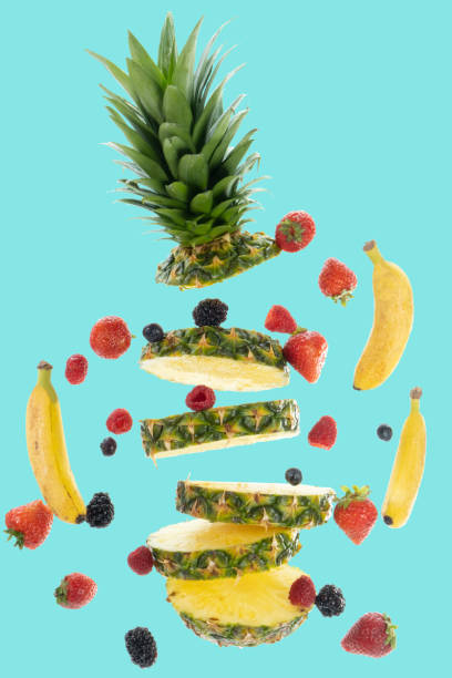 istock Pineapple, bananas, berries flying apart on blue background 1474024481