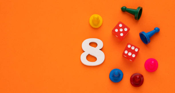 istock Number 8 with dice and board game pieces - Orange eva rubber background 1474024489
