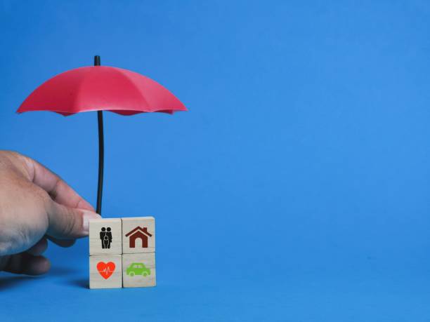 istock Insurance coverage concept on wooden cubes with hand holding mini umbrella. 1474030932