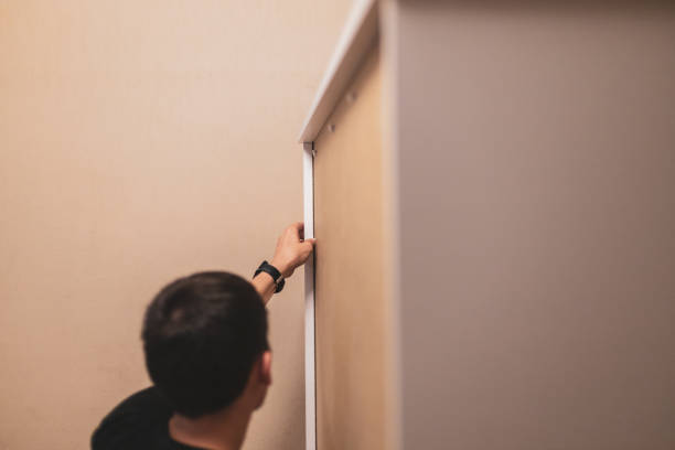 istock A young man installs rivets on a wardrobe. 1474033174