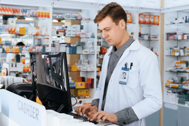 istock Inventory work in qualified drugstore with male pharmacist using computer. 1474033711