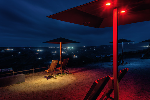Umbrellas at the viewpoint of the Hambach brown coal mine at night, in Elsdorf, Germany