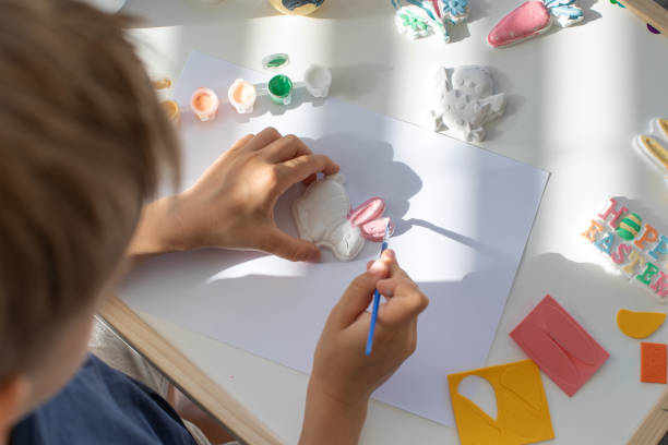 istock A child paints an Easter bunny figurine. Easter children's crafts. 1474039941