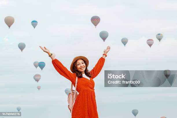 The Sun Shone Down On The Girl As She Observed Air Balloons Drift Away She Wearing A Gorgeous Red Dress Stock Photo - Download Image Now