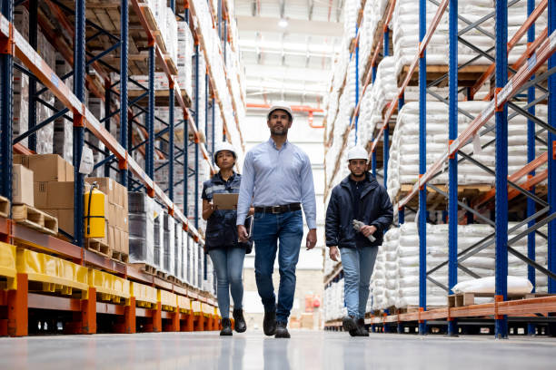 istock Group of workers walking around a distribution warehouse 1474043702