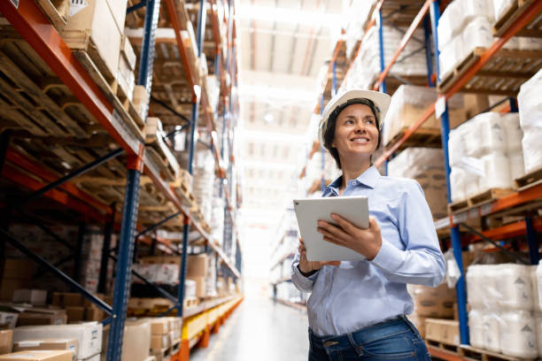 Woman supervising the operation of a distribution warehouse Latin American woman supervising the operation of a distribution warehouse while using a tablet computer mediterranean ethnicity stock pictures, royalty-free photos & images