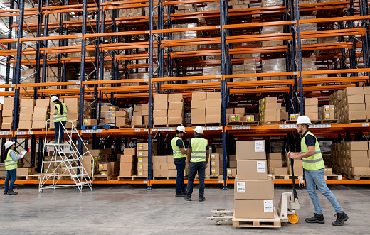 Group of Latin American employees working at a distribution warehouse - global business concepts
