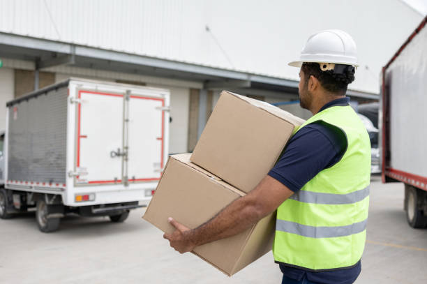 istock Man working at a distribuion warehouse loading boxes on a cargo truck 1474043762