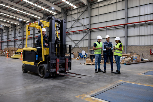 Group of Latin American employees working at a distribution warehouse shipping merchadise - supply chain concepts