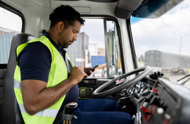 istock Truck driver transporting merchandise and using a GPS system on his cell phone 1474043845