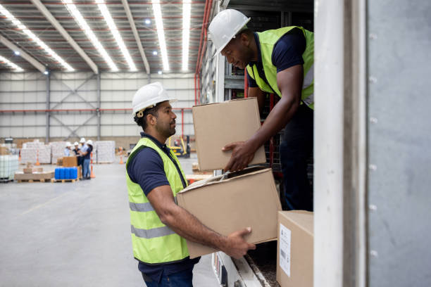 istock Team of operators loading boxes on a truck at a distribution warehouse 1474044641